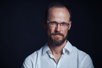 Obraz premium Concentraited middle age man in white shirt and eyeglasses looking squinting at camera
