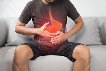 Acid reflux or Heartburn, The photo of stomach is on the men's body against gray Background, Bad health, Male anatomy concept