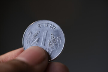 indian 1 rupee coin on the hand
