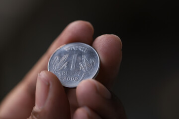 indian 1 rupee coin on the hand