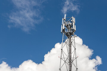Bottom perspective pov of modern metal steel mobile 5g network wireless telecom tower against clear blue sky background on bright day. Microwave signal broadband equipment base line station mast