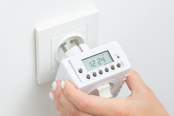 Plugin outlet timer-computer to the socket. Controlling usage of electricity of electronic devices by smart outlet adapter