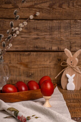 Fototapeta na wymiar on a wooden background Easter eggs, painted with natural vegetable dyes, onion peel, next to a wooden Easter Bunny and willow