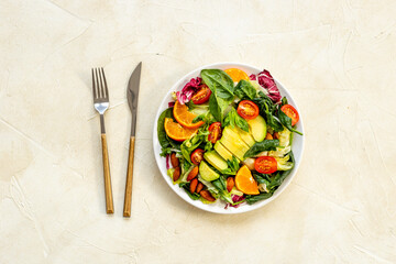 Healthy vegetarian bowl of green salad with avocado and tomatoes
