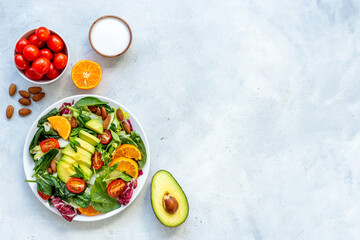 Fototapeta na wymiar Bowl full of healthy vegetarian salad with avocado and tomatoes