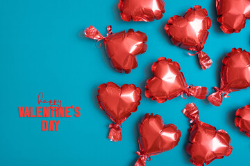 Happy Valentines Day text with red heart shape balloons on turquoise background