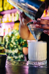 man hand bartender making white cocktail in glass on the bar counter