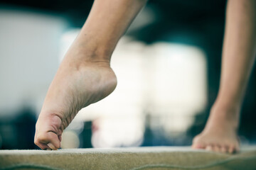Gymnastics, fitness and feet of person in studio for balance, training and exercise against blurred background. Foot, workout and acrobat on beam for posture, routine and performance with mockup