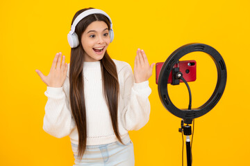 Teenage girl blogger making video, child vlogger influencer record content, brand advertising promo. Child blogger records video on mobile phone using ring lamp, video lights for blog or vlog.