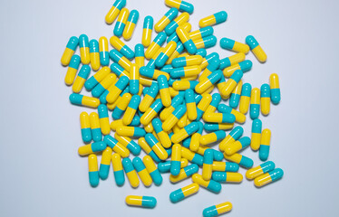 Pills and capsules were scattered on blue background. 