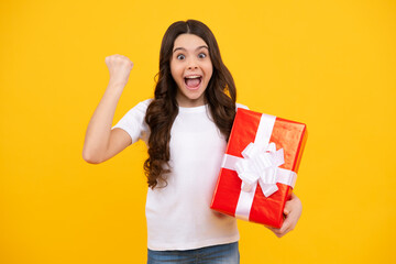 Amazed teenager. Portrait of teenager child girl 12, 13, 14, years old holding Christmas gift box. Teen giving birthday gift. Excited teen girl.