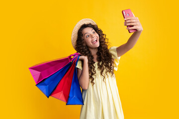 Shopping bags and mobile phone in the kids hands. Teen girl after shopping. Purchases, black friday, discounts and sale concept. Summer shopping sale.