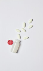 Medicine, on a light background and in a small and scattered container. Vertical shot and copy space.
