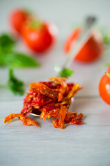 small pieces of dried tomatoes next to fresh tomatoes