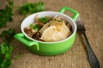 Potato dumplings with onion and mushrooms in a plate.