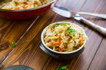 Braised cabbage with carrots, onions and herbs in a ceramic bowl