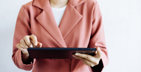 A picture of a businesswoman working on a tablet with a clean white background