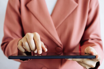 Photo of a business woman hand touching a tablet