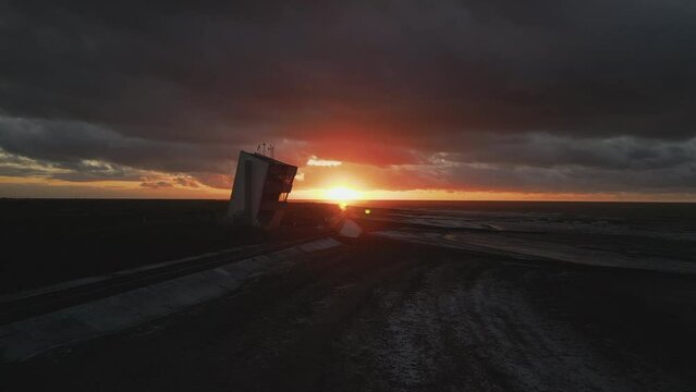 Sunset over NCI watchtower during stormy weather in winter