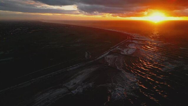 Sunset over slow motion waves at Rossall Point in winter