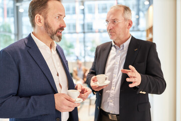 Geschäftsleute in einer Kaffeepause beim Smalltalk