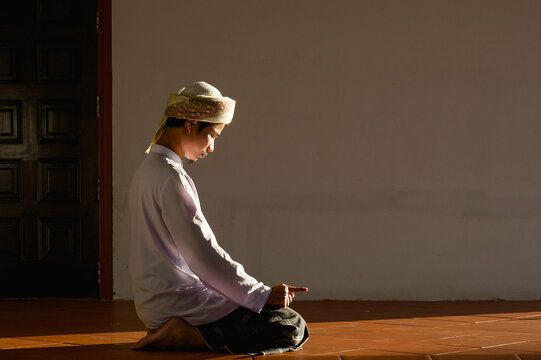 Religious muslim islam man in white session with prayer action to Allah in mosque on black background .concept for islamic pray, Ramadan, Eid al Fitr, eid ad-ha, meditation