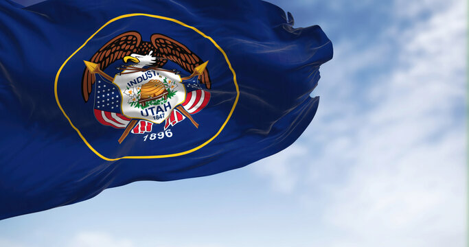 The Utah state flag fluttering in the wind on a sunny day