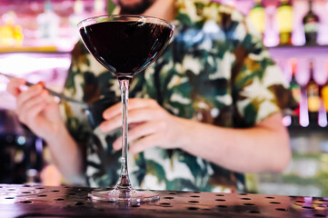 man bartender hand making red cocktail on bar