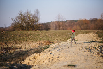 Cute little girl having fun in nature. A beautiful child poses outdoors on a sunny day in early...