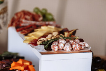 Appetizers table with meat and cheese. Salami, sausages, variation of cheese, grapes, tomatoes,...