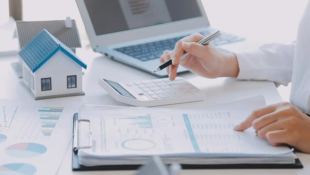 Real estate broker agent presenting and consult to customer to decision making sign insurance form agreement, buy and sell home model, concerning mortgage loan offer for and house insurance