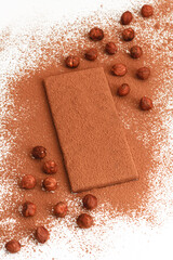 Hazelnuts with a bar of chocolate sprinkled with cocoa