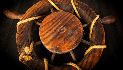 Closeup view of vintage ship wheel with ropes around
