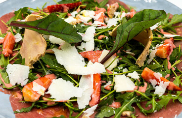 Carpaccio de ternera con queso parmesano y brotes verdes