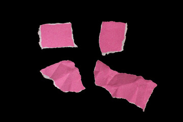 Torn pink paper piece isolated on black background