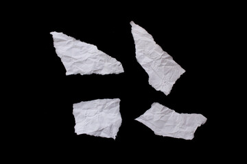 Torn crumpled paper piece isolated on black background
