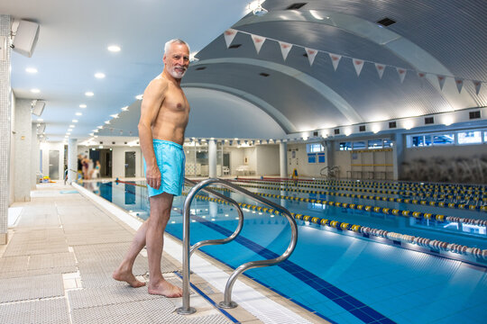 Good-looking Fit Senior Man In Blue Swim Shorts At The Swimming Pool