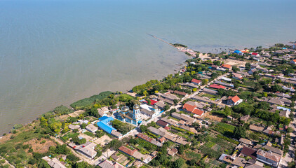 Aerial view of Sarichioi village in Dobrogea Romania during summer sunny day with view to the orthodox church landmark