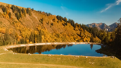 Beautiful alpine autumn or indian summer landscape shot with reflections in a pond at the famous Loferer Alm, Lofer, Salzburg, Austria
