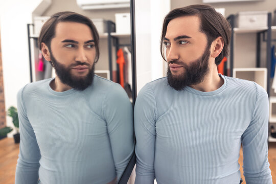 Male looking at his appearance after the makeup application