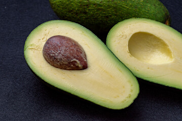 Cut avocado fruit, Variety: Fuerte, Black felt background