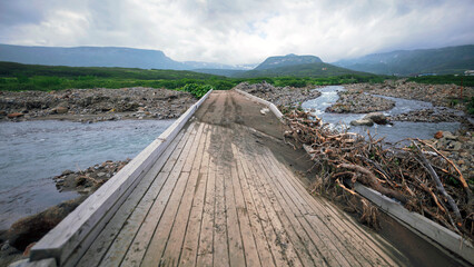 Severo-Kurilsk, Russia. A wooden bridge over a river damaged by heavy rainfall during the rainy season. Paramushir Kuril Island in the Pacific Ocean.