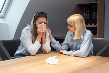 Young friend woman comforting her sad depressed colleague in office who crying after mistake at...