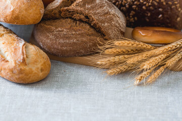 Fresh delicious bread close-up. Freshly baked sourdough bread with a golden crust on a wooden board. The context of a bakery with delicious bread. Confectionery products.