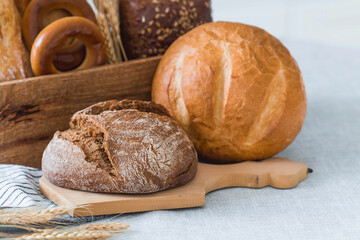 Fresh delicious bread close-up. Freshly baked sourdough bread with a golden crust on a wooden board. The context of a bakery with delicious bread. Confectionery products.