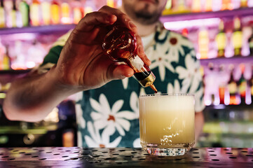man hand bartender making white cocktail in glass on the bar counter