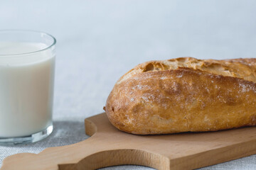 Fresh delicious bread close-up. Freshly baked sourdough bread with a golden crust on a wooden board. The context of a bakery with delicious bread. Confectionery products.