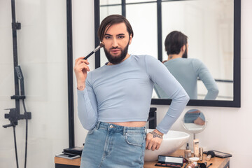 Guy applying powder to the face in the bathroom