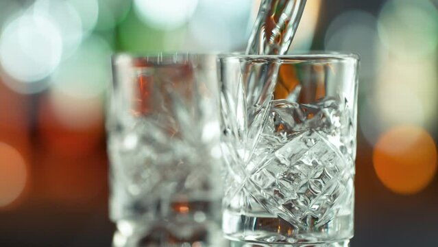 Super Slow Motion Shot of Pouring Transparent Alcohol Liquid into Shot Glass on Bar at 1000fps.