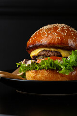 Close up of Tasty burger  with sauce fast food top view on black table